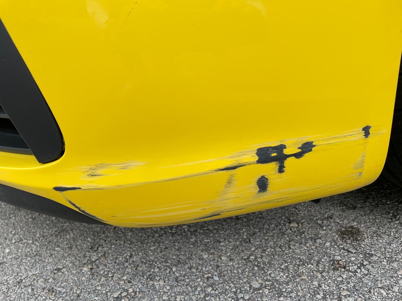 The same yellow Porsche before repair, showing collision damage